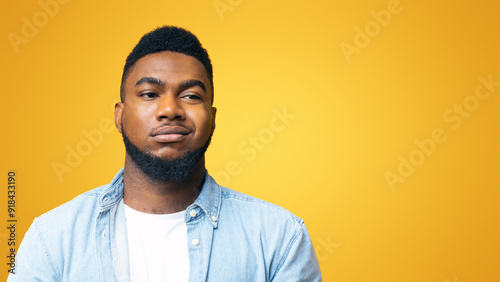 Portrait of african american man with sceptical face expression over yellow background with copy space