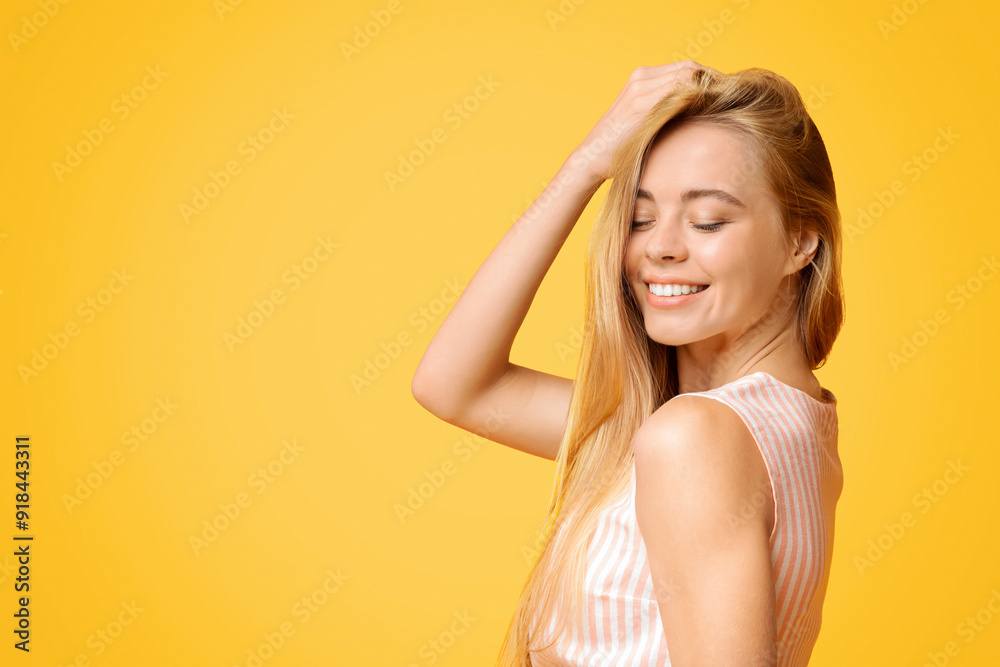 Teen Beauty. Cute Young Girl Enjoying Touching Her Beautiful Blond Hair, Posing Over Yellow Background, Closeup Portrait
