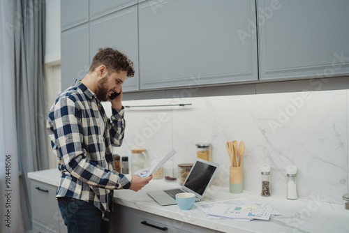 High angle view of an young brunette working at her office desk with documents and laptop.