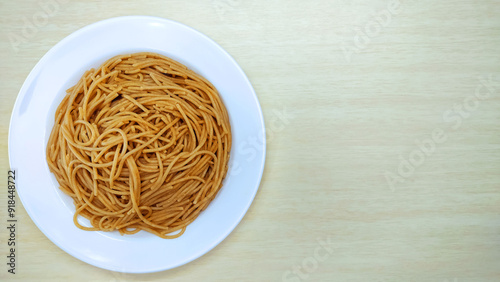 Plate with wholemeal spaghetti pasta on the wooden background with copy space and space to write text 