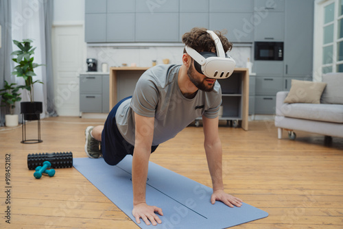 Beautiful young man in sports clothing exercising at home