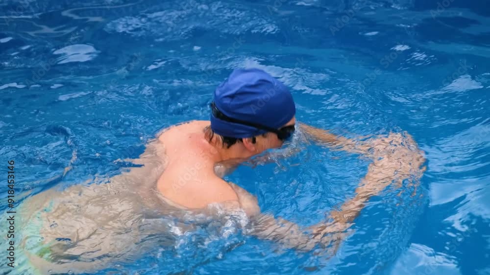 Athletic man swimming breaststroke in a clear outdoor pool. Perfect for fitness, lifestyle, and sports content Athletic man swimming breaststroke in a clear outdoor pool. Perfect for fitness, lifestyle, and sports content