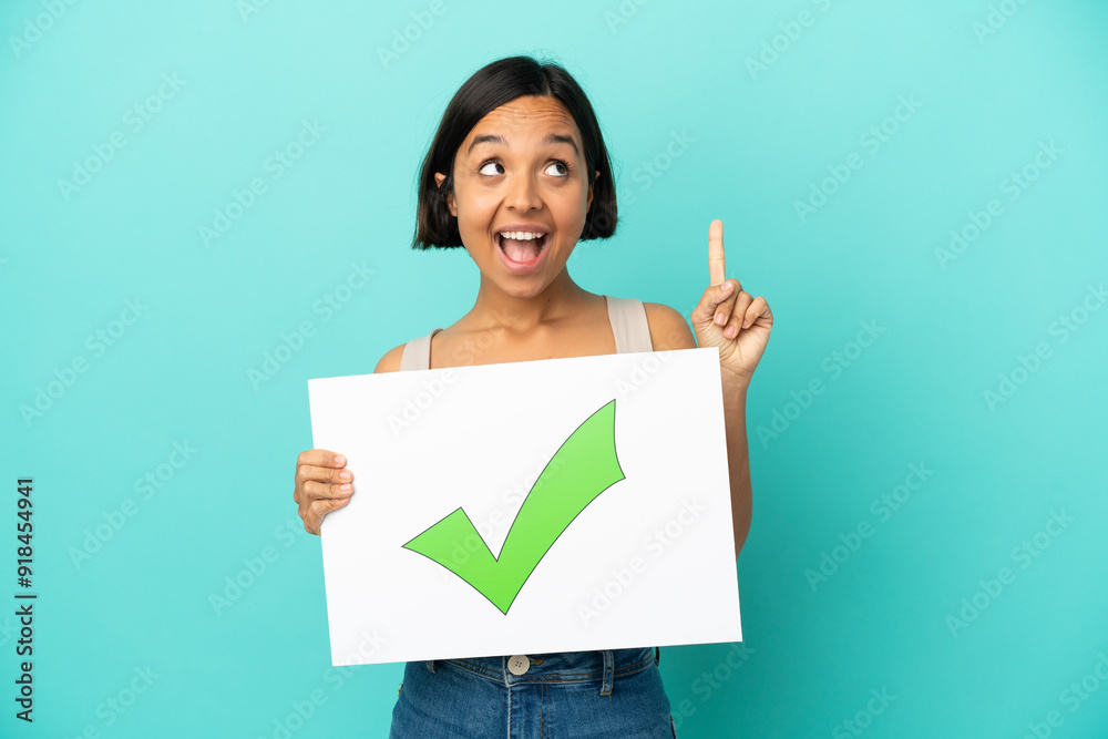 Young mixed race woman isolated on blue background holding a placard with text Green check mark icon and thinking Young mixed race woman isolated on blue background holding a placard with text Green check mark icon and thinking