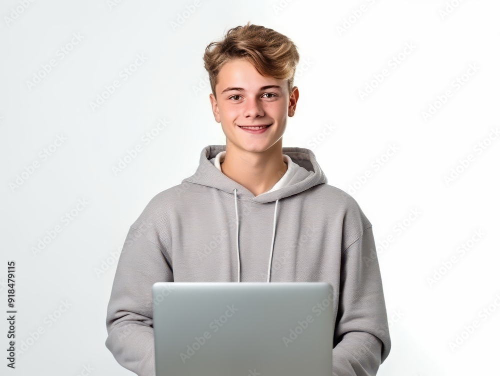 Teen smiling while working on a laptop indoors