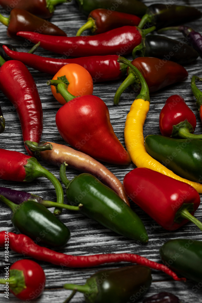 Mix of hot cayenne peppers, buena mulata and jalapeños on the table. Top view. Mix of hot cayenne peppers, buena mulata and jalapeños on the table. Top view.