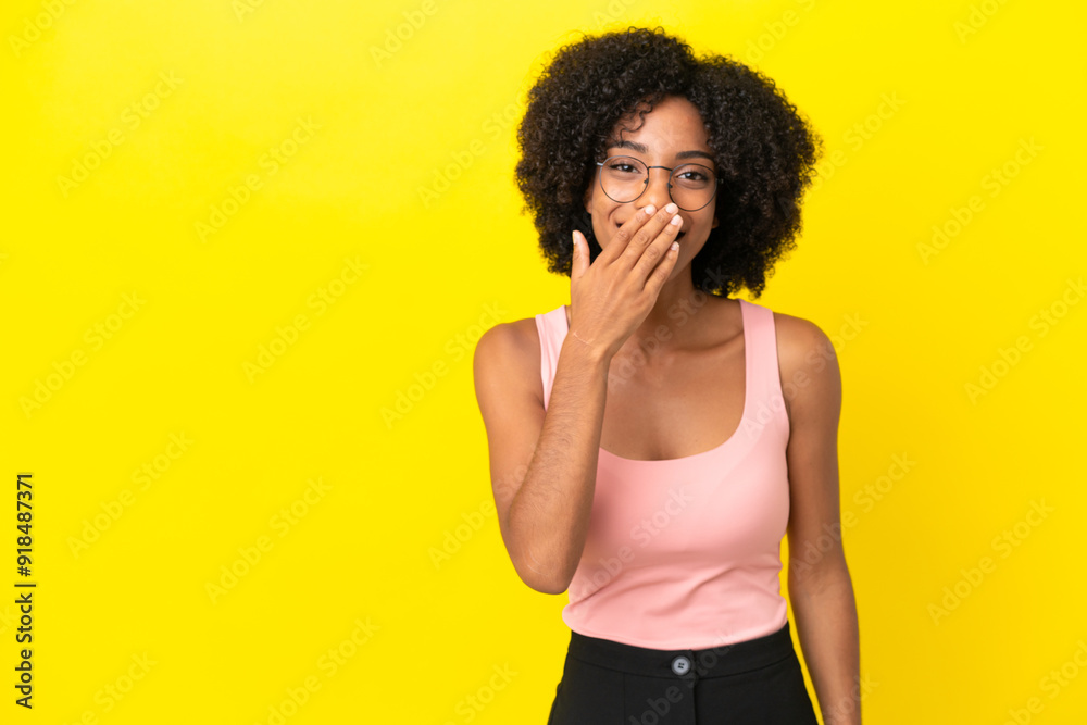 Young African American woman isolated on yellow background happy and smiling covering mouth with hand Young African American woman isolated on yellow background happy and smiling covering mouth with hand