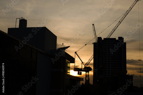 Photograph of the orange sky as the sun sets over the rooftops of buildings