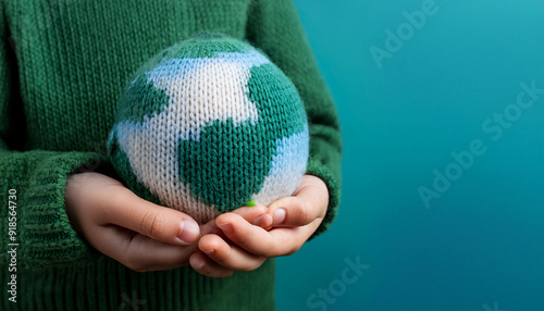 Earthglobe knitted from wool holded in Childs hands.  photo