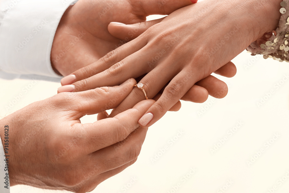 Man putting engagement ring on woman's finger, closeup Man putting engagement ring on woman's finger, closeup