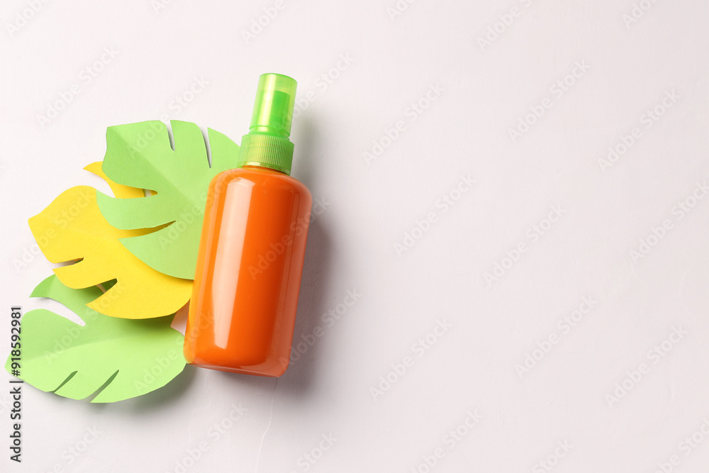 Bottle of sunscreen cream with paper palm leaves on white background Bottle of sunscreen cream with paper palm leaves on white background