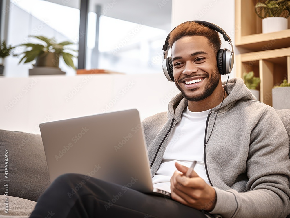 Man enjoying music while using laptop at home Man enjoying music while using laptop at home