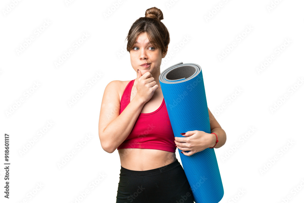 Young sport girl going to yoga classes while holding a mat over isolated chroma key background having doubts and thinking Young sport girl going to yoga classes while holding a mat over isolated chroma key background having doubts and thinking