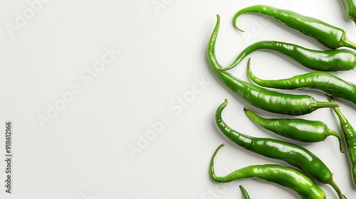 Green chili peppers arranged in a curved pattern on a white background. photo