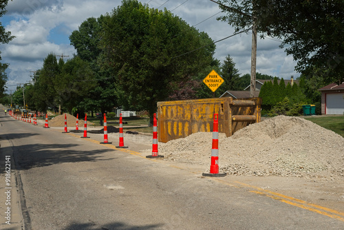 Road work with traffic cones for lane closure and trench box for excavating space for water line replacement