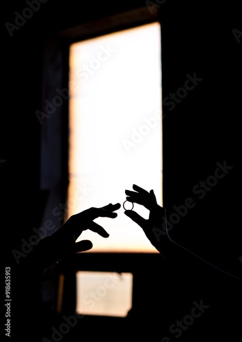 Hands with wedding rings on a light