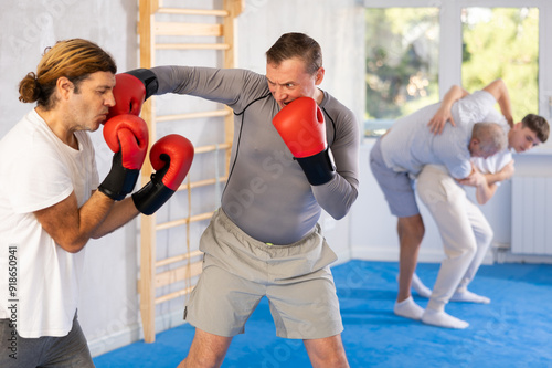 Male co-participant and man sparring partners during training battle fight using technique of boxing match. Boxing section for men, sport as lifestyle photo