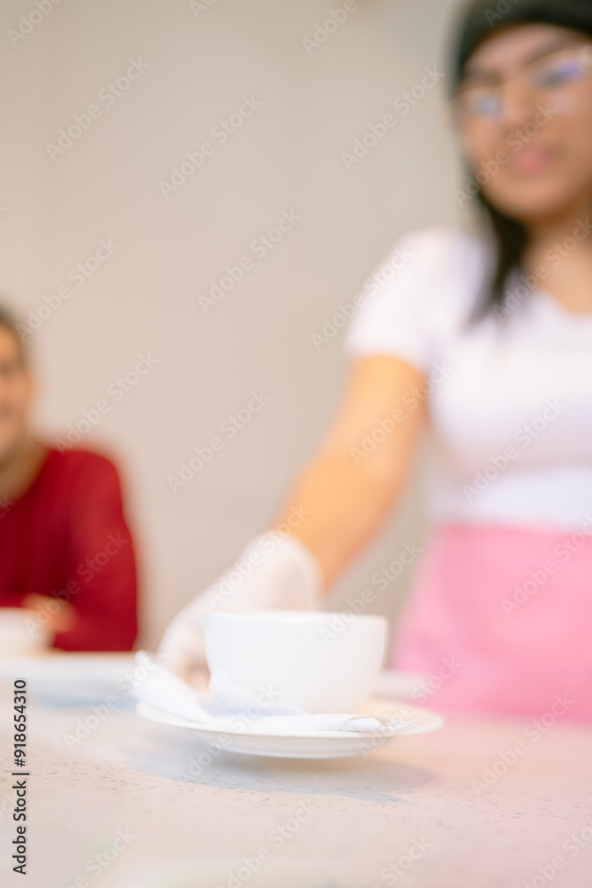 Waitress serving coffee in coffee shop to customer Waitress serving coffee in coffee shop to customer