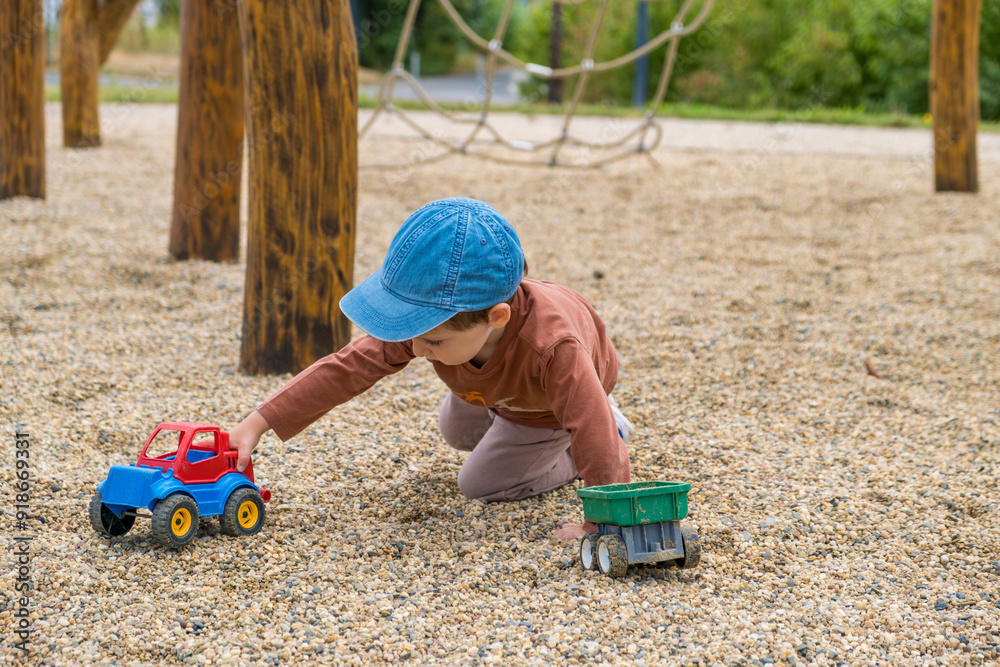 A little barefoot boy in brown clothes is walking on a modern wooden playground A little barefoot boy in brown clothes is walking on a modern wooden playground