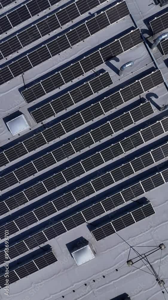Solar Panels on Shopping Center Rooftop. Aerial shot of a parking lot and a shopping center roof covered with solar panels. Utena, Lithuania. Solar Panels on Shopping Center Rooftop. Aerial shot of a parking lot and a shopping center roof covered with solar panels. Utena, Lithuania.