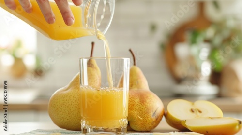 Woman pouring self-made pear juice into glass, healthy food photo