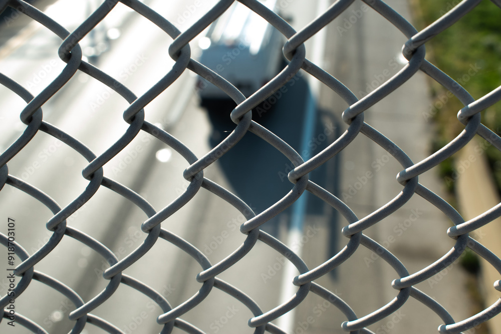 Fototapeta premium semi truck viewed through fencing on a bridge