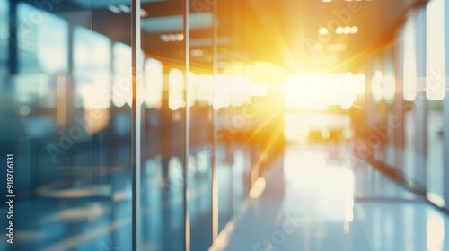 Blurry view of a sunlit office hallway with glass walls.