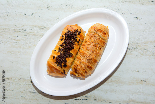 Two banana bolen cakes in chocolate and cheese flavors on a white plate photo