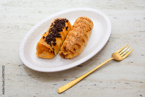 Two banana bolen cakes in chocolate and cheese flavors on a white plate