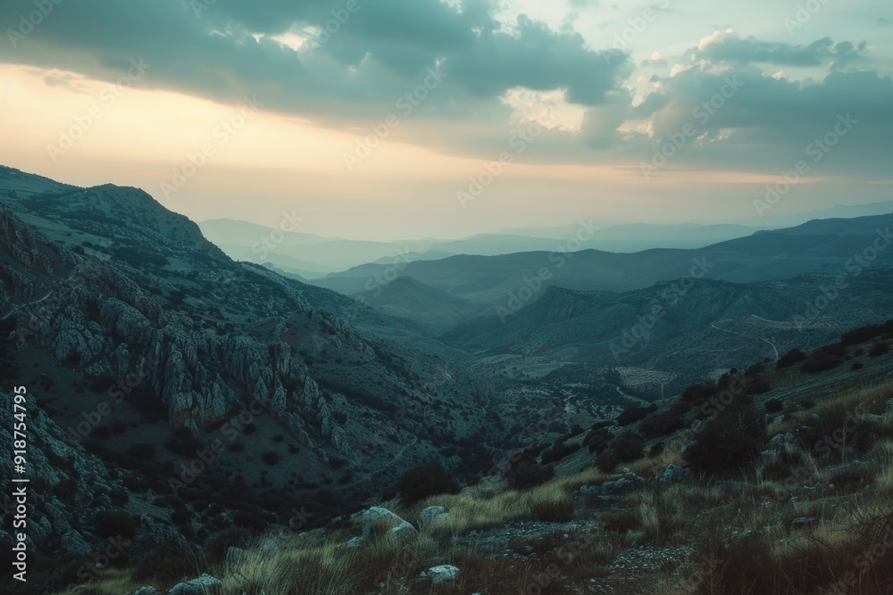 A scenic view of a mountain range with a cloudy sky
