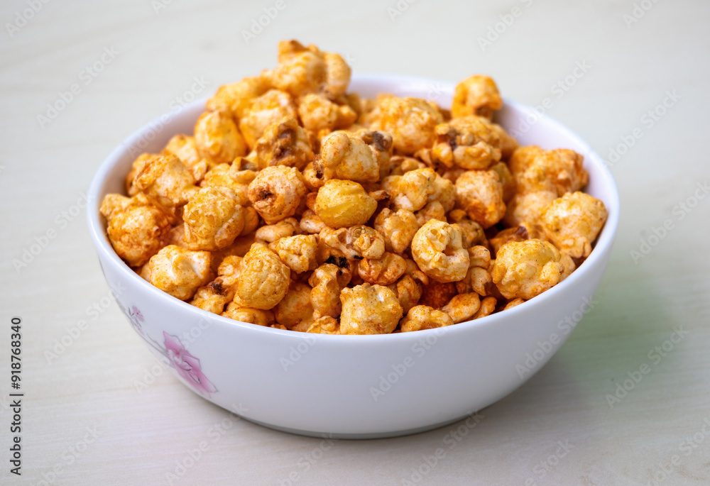 Bowl of barbecue flavored popcorn on light wooden background. Bowl of barbecue flavored popcorn on light wooden background.