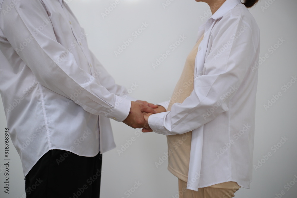 A young man hugs his pregnant wife while standing in a room in his house. A young man hugs his pregnant wife while standing in a room in his house.