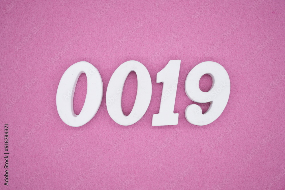The numbers are made of white painted wood. Laying on the floor was pink paper. The numbers are made of white painted wood. Laying on the floor was pink paper.