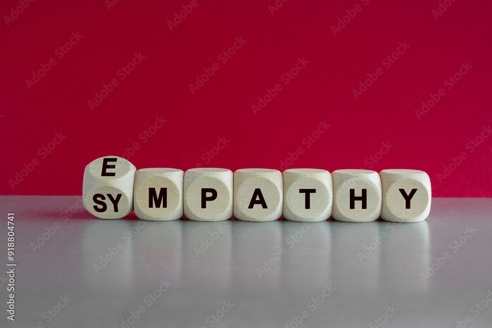 Sympathy or empathy symbol. Turned a wooden cubes and changed the concept word Empathy to Sympathy. Beautiful grey table pink background. Psychological sympathy or empathy concept.