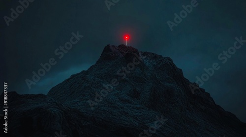 A lone red light on top of a mountain at night