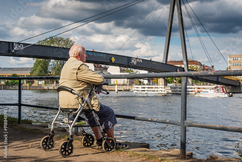 Old Granpa sitting on Spree Banks, An older man sits on his walker on the banks of the Spree and looks into the distance, Rollator