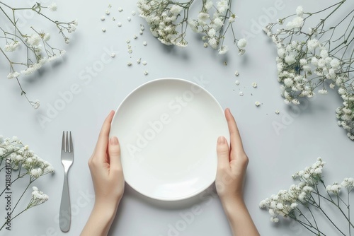 A person holds a plate with utensils ready to eat, great for food related content or everyday life scenes photo