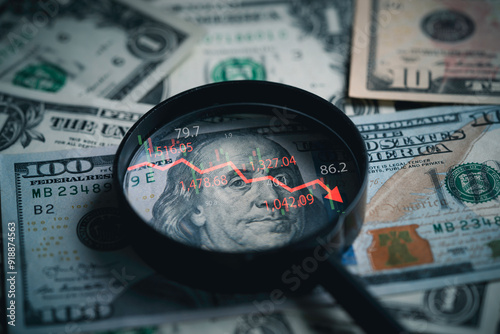 Red down arrow inside of magnifier glass and USD dollar banknote for United States of America or USA economic recession crisis and Fed reduce interest concept.