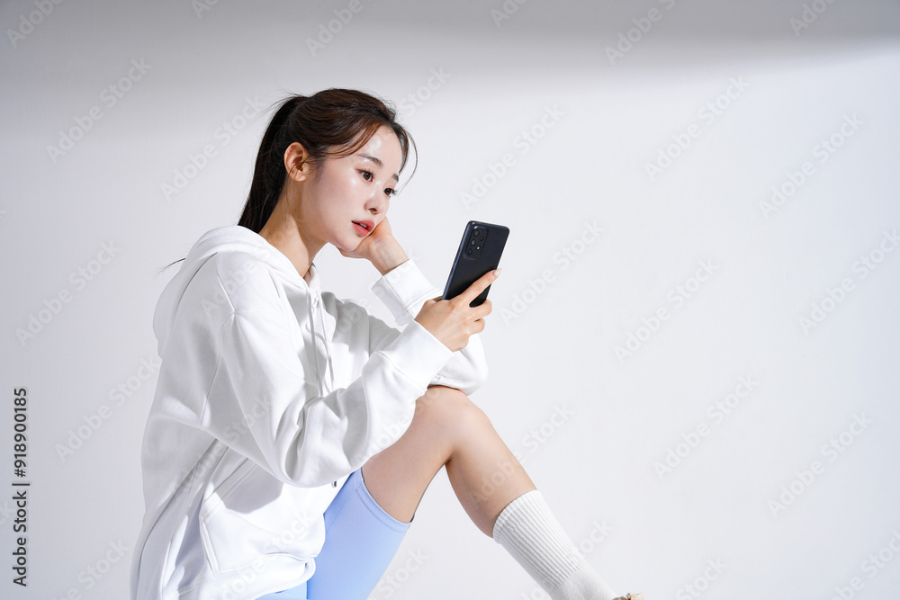 スポーティなファッションをした若い女性のスタイリッシュなポートレート スポーティなファッションをした若い女性のスタイリッシュなポートレート