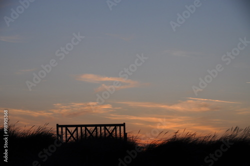 Silhouette einer Sitzbank in den Dünen am Meer beim Sonnenuntergang - Ruhe und Entspannung in der Natur