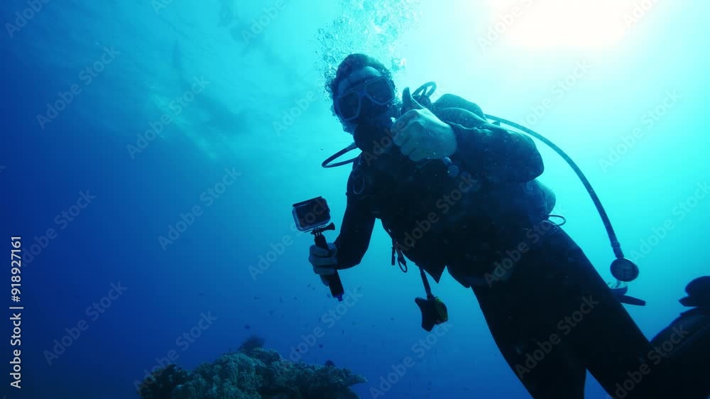 Diver blogger descends to seabed showing thumbs up Diver blogger descends to seabed showing thumbs up