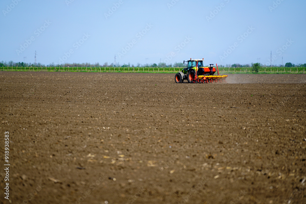 Obraz premium Agricultural land is cultivated by a tractor, sowing seeds.