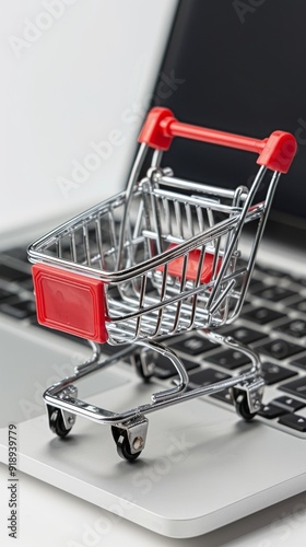 A high-resolution, photorealistic image of a miniature shopping cart positioned on top of an open laptop computer, symbolizing online e-commerce and digital marketing concepts