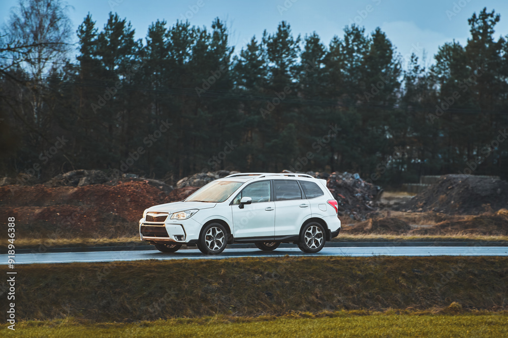 compact crossover suv car driving on the road near forest compact crossover suv car driving on the road near forest