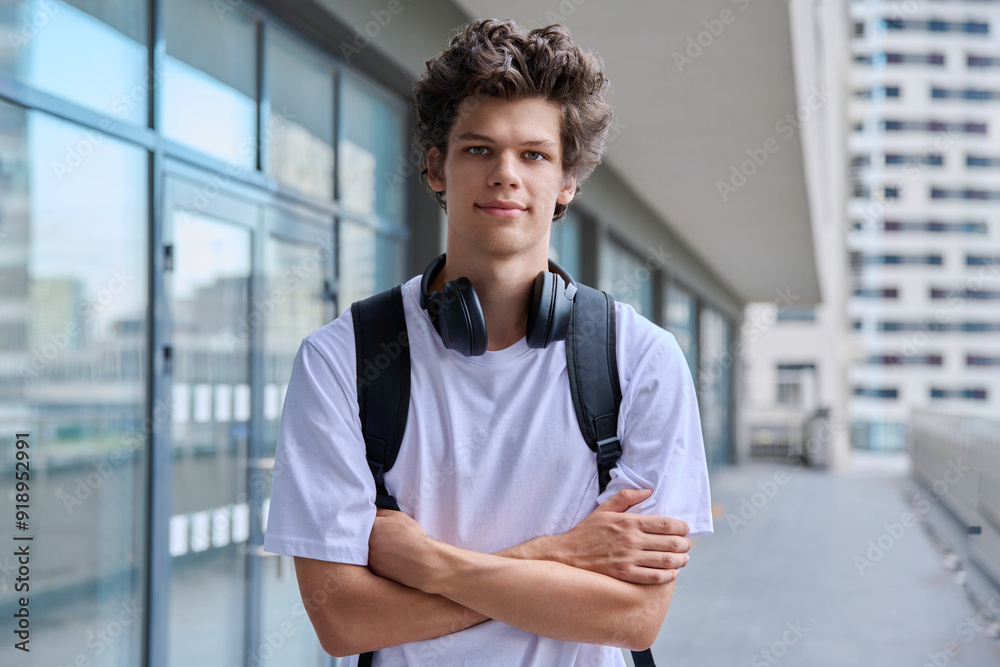 Handsome young man looking at camera outdoors, modern skyscrapers urban style background Handsome young man looking at camera outdoors, modern skyscrapers urban style background