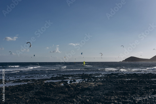 Men professional surfer standing on the sandy beach with his kite and board. Windsurfing, Extreme Sport photo