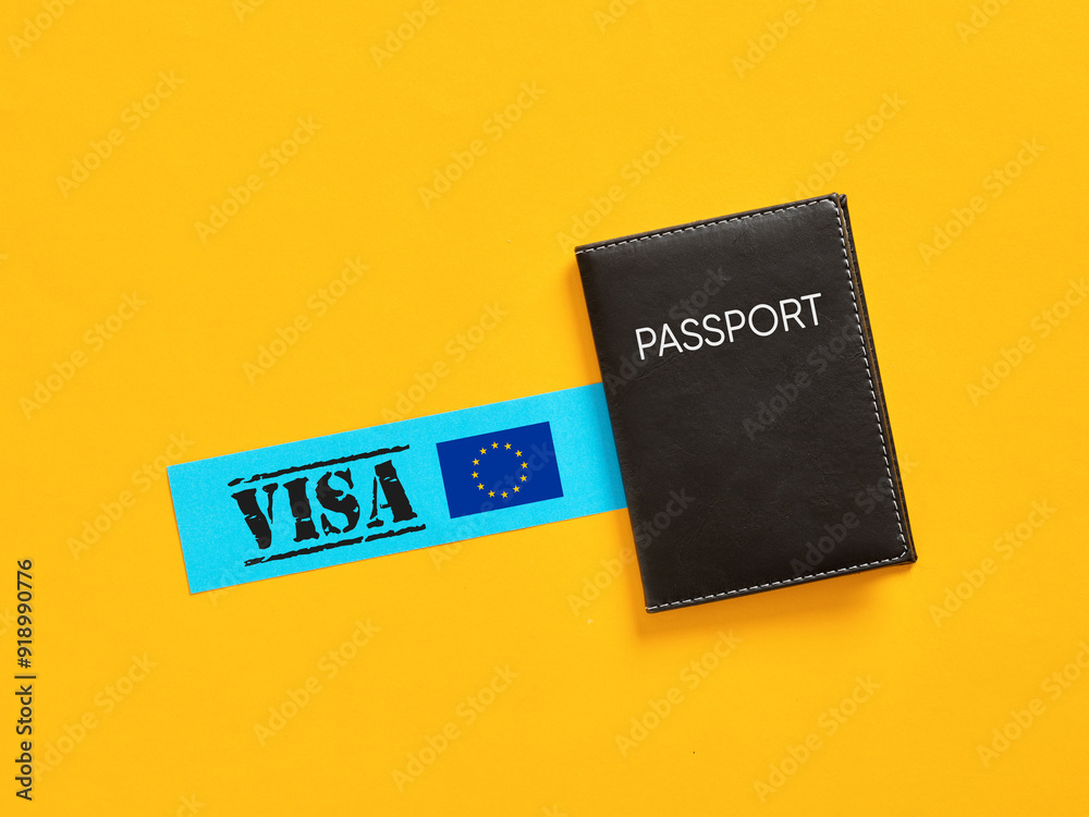 Black passport lying near blue paper showing european union flag and visa text on yellow background Black passport lying near blue paper showing european union flag and visa text on yellow background