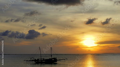 Herrlich warmer Sonnenuntergang mit großem Fischerbootbei Nembrala in Westtimor auf der Insel Rote Barat photo