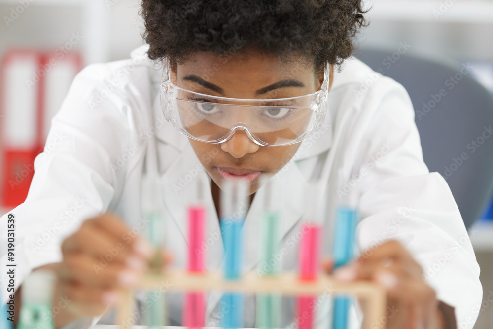 professional woman is pipetting solution into the glass professional woman is pipetting solution into the glass