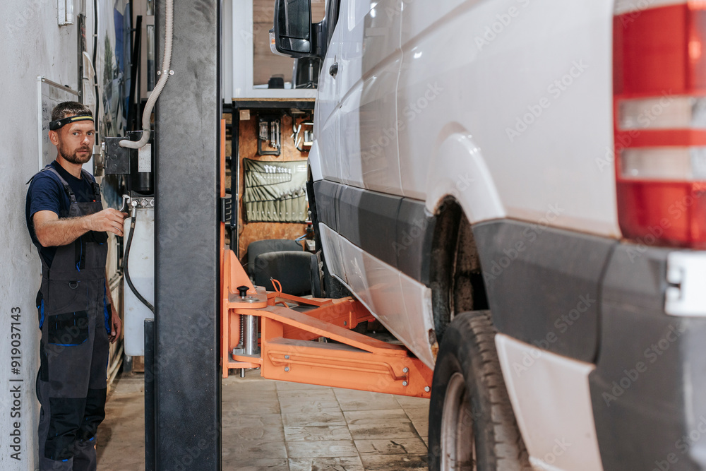 Auto expert working on vehicle maintenance inside garage Auto expert working on vehicle maintenance inside garage