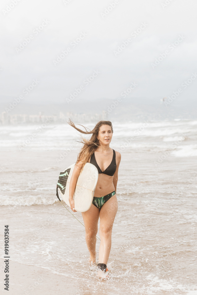 Obraz premium Surfer with surfboard walking on sea beach